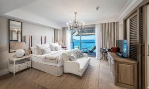 亚力卡瓦克Allium Bodrum Resort & Spa的一间卧室配有一张床、一台电视和一张沙发