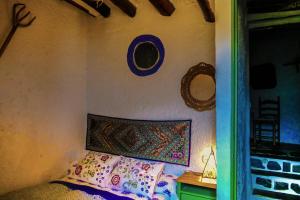 特雷韦莱斯绿色灯泡度假屋的一间卧室配有一张床和一面镜子的墙壁