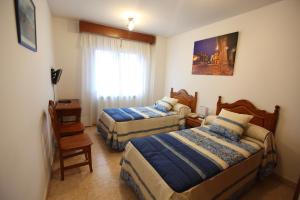 拉阿贝尔卡Hostal San Blas的酒店客房设有两张床和窗户。