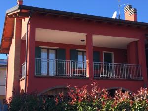 卢加尼亚诺Casa Dany的一间红色的房子,旁边设有阳台
