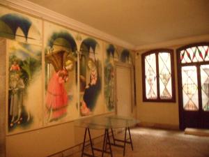 威尼斯Luxury apartment on the Grand Canal的一间房间,配有一张桌子,墙上挂着一些绘画作品