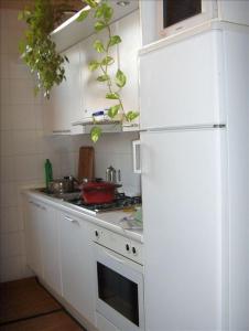 威尼斯Luxury apartment on the Grand Canal的厨房配有白色橱柜和白色冰箱。