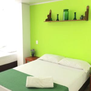圣安德烈斯La Posada De Lulú的绿色卧室,配有一张带绿色墙壁的床