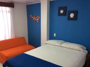 圣安德烈斯La Posada De Lulú的一间卧室配有一张床和一张橙色椅子