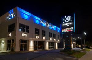德拉蒙德维尔Hotel & Suites Le Dauphin Drummondville的一座酒店大楼,晚上有蓝色的灯光