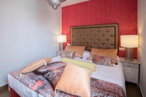 英格兰海滩Alhambra Boutique Apartments by TAM Resorts的一间卧室设有一张红色墙壁的大床