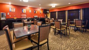 卡本代尔贝斯特韦斯特 - 萨路基旅馆的用餐室设有桌椅和橙色墙壁