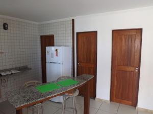 劳鲁-迪弗雷塔斯Pousada Restinga Apart Service- Aeroporto的厨房配有柜台和白色冰箱。
