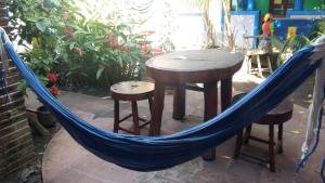格拉纳达Hostal Mochilas的吊床,配有桌子、两张凳子和一张桌子