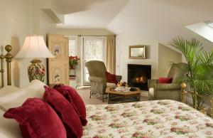 纽波特Hydrangea House Inn的一间卧室设有一张床,客厅设有壁炉。