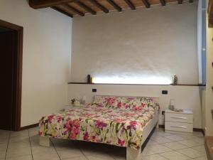 比森齐奥营Luigi Home的一间卧室配有一张带花卉床罩的床和窗户。