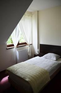 Tokarnia希纳蒙酒店的一间卧室设有一张床和一个窗口