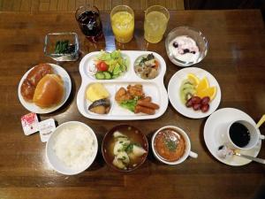 松本松本市南十字星经济型酒店的一张木桌,上面放着食物和饮料