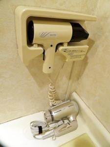 松本松本市南十字星经济型酒店的浴室内与卫生间相连的吹风机