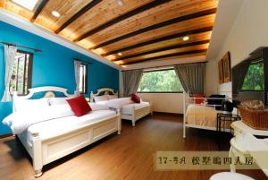 鹿谷乡溪头曼陀乡民宿的一间卧室设有两张白色的床和蓝色的墙壁
