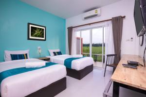 武里南Xaiyong Resort - ไทรโยงรีสอร์ท的酒店客房设有两张床和一个阳台。