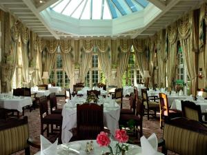 胡克泰尔尼大厅酒店的一间带桌椅和天窗的用餐室