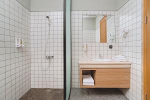 万隆Mogens Guesthouse的一间带水槽、淋浴和镜子的浴室