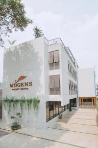 万隆Mogens Guesthouse的白色的建筑,上面有摩根标志