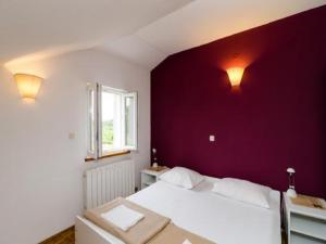 格鲁达Apartment Dubrovnik Banac的卧室配有白色的床和紫色墙壁