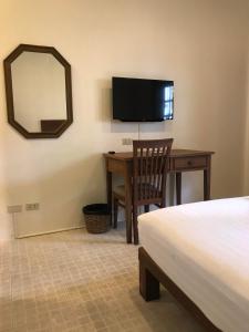 象岛棕榈花园公寓的一间卧室配有书桌、一张床和镜子