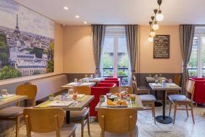 巴黎蒙马特阿利泽康泰科特酒店的餐厅设有桌椅和窗户。