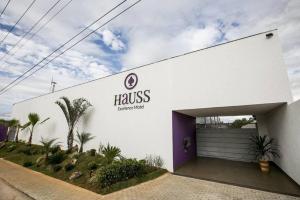 塞蒂拉瓜斯Hauss Excellence Motel的一座白色的大建筑,设有紫色车库