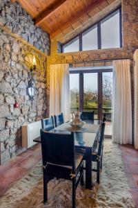 波利兹罗松Naiades Village的一间设有桌椅和石墙的用餐室