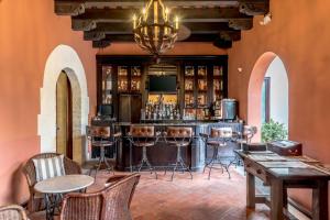 圣多明各霍德帕尼古拉斯奥万多酒店的一间酒吧,位于带桌椅的房间