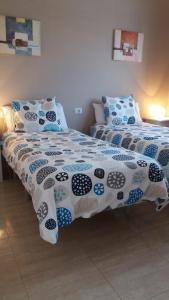 卡门港Departamento Joelle的一间卧室配有两张带蓝白色床单的床