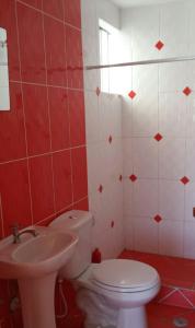 伊洛Departamento vista al mar的红色和白色的浴室设有卫生间和水槽