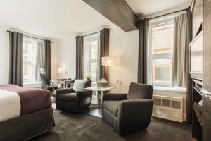 魁北克市考特里尔酒店的酒店客房带一张床、椅子和窗户