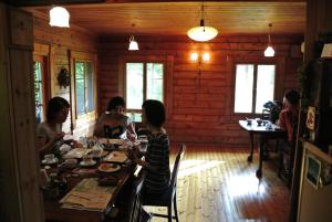 南小国町风之味住宿加早餐旅馆的一群人坐在小屋的桌子上