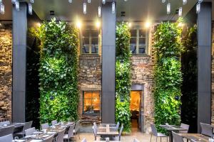 里加里加老城普尔曼酒店的餐厅设有绿色墙壁,配有桌椅