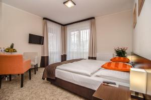 梅尔诺伊莫思雅SPA酒店的酒店客房配有一张床铺、一张桌子和一张书桌。
