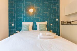 巴黎Apartments WS St Germain - Quartier Latin的卧室配有白色床和蓝色墙壁