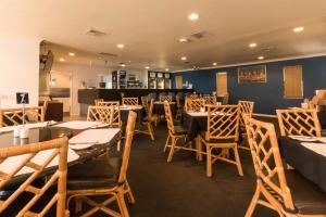 珀斯山王马拉克达珀斯机场酒店的一间在房间内配有桌椅的餐厅