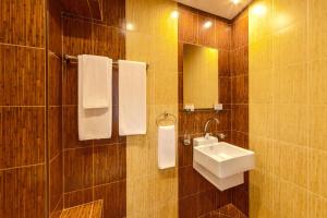 索非亚Eleganza Family Hotel的浴室配有盥洗盆、镜子和毛巾