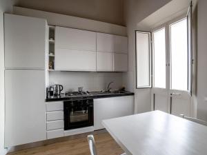 马尔米堡Casa Desy的厨房配有白色橱柜和白色桌子