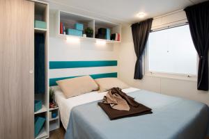 瓦达Toscana Bella Camping Village的一间小卧室,配有两张床和窗户