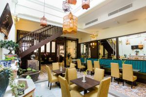 马六甲艾瓦马六甲酒店的一间带桌椅的餐厅,以及楼梯