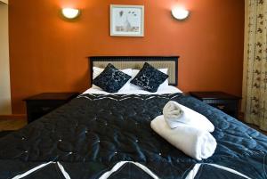 埃尔森汉姆得萨利斯伦敦斯坦斯特德酒店的一间卧室配有一张床,上面有两条毛巾
