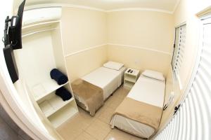 坎皮纳斯Residencial Villa Container的小房间设有两张床和镜子