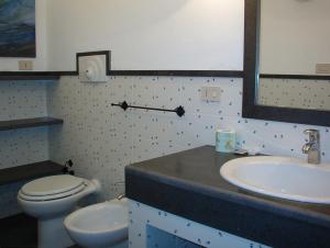 焦约萨马雷阿Residence L'uliveto的一间带水槽、卫生间和镜子的浴室