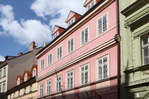 布拉格艾格尼斯居苑酒店的街道边的粉红色建筑