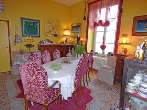 普勒尔蒂八仙花属住宿加早餐旅馆的用餐室配有带紫色椅子的桌子