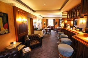 史塔卡赫祖姆格尔登欧森林酒店的一间酒吧,在房间内配有沙发和椅子