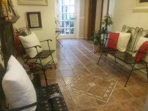 莫纳汉阿什雷旅馆的客厅配有椅子,铺有瓷砖地板。