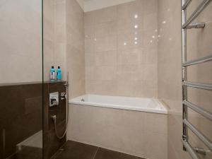 塔林哈留老城公寓的设有带浴缸和淋浴的浴室。