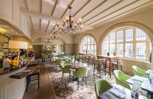 林德赫斯特贝斯特韦斯特王冠酒店的餐厅设有绿色的椅子和桌子以及窗户。